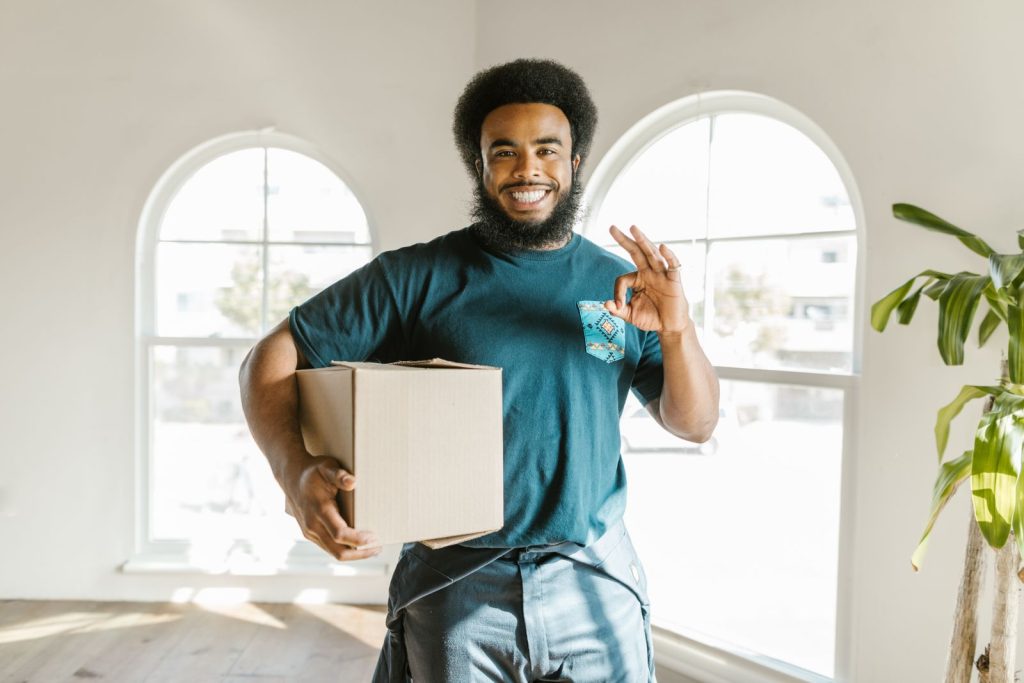 Legend Movers mover carrying a box into a home in Plano, Texas